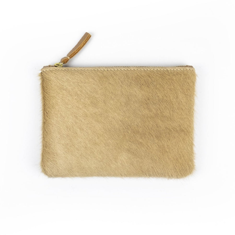 Light tan colored coin pouch made of cowhide. Laying on a white background and has a tan, leather zipper pull sticking out.