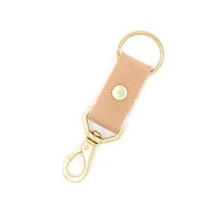 Tan colored leather keychain with brass handles on white background