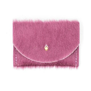 Lilac colored card holder made with cowhide in a rectangular shape. It has a small, gold colored circular clasp in the middle.