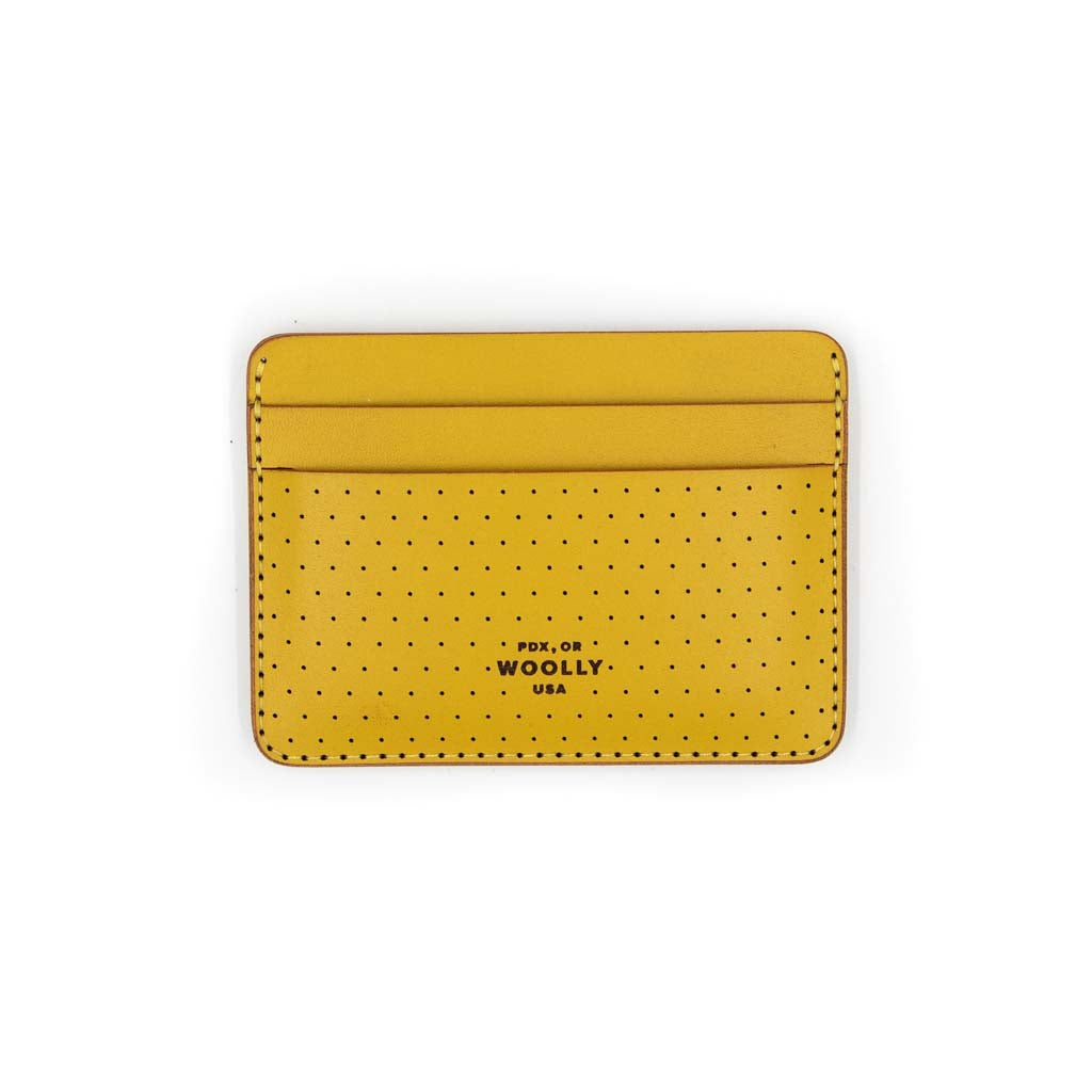 Yellow perf half wallet with stitching around the border and small holes on the bottom half of wallet. Bottom of wallet says "PDX, OR WOOLLY USA"