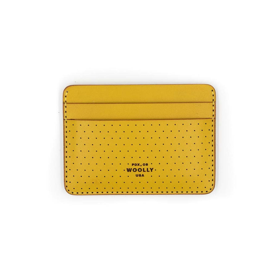 Yellow perf half wallet with stitching around the border and small holes on the bottom half of wallet. Bottom of wallet says "PDX, OR WOOLLY USA"