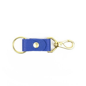 Blue leather keychain with brass handles on a white background.