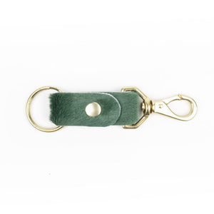 Kelp green colored keychain made of cowhide with brass handles on a white background