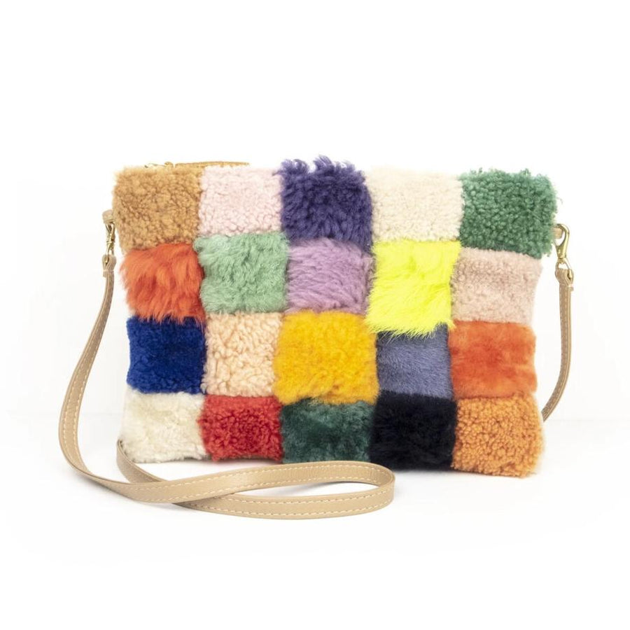 Patchwork, multi-colored sherling bag with khaki colored leather strap on white background